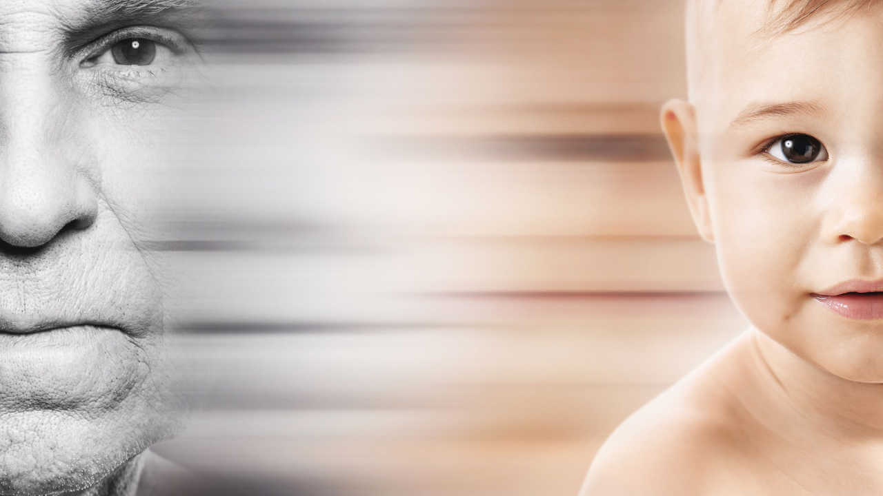 Metade do rosto de um homem idoso em preto e branco ao lado da metade do rosto de um bebê colorido, com efeito de transição suave entre as imagens.